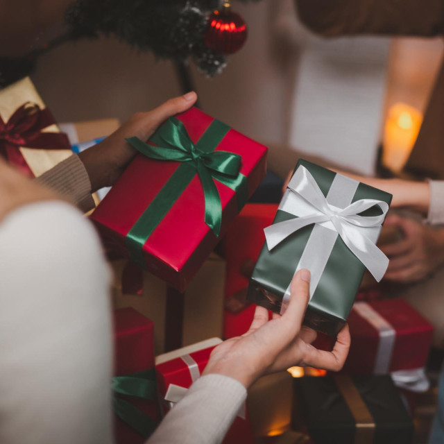 Excited asian woman getting surprise gift from her girlfriend at home. Gives a gift.Asian woman decor bauble ball Christmas tree in xmas holiday winter seasonal celebration