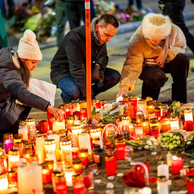 Ožalošćeni pale svijeće na improviziranom memorijalu u blizini mjesta požara koji je tijekom proslave Nove godine zahvatio bar u alpskom skijališnom gradu Crans-Montani.