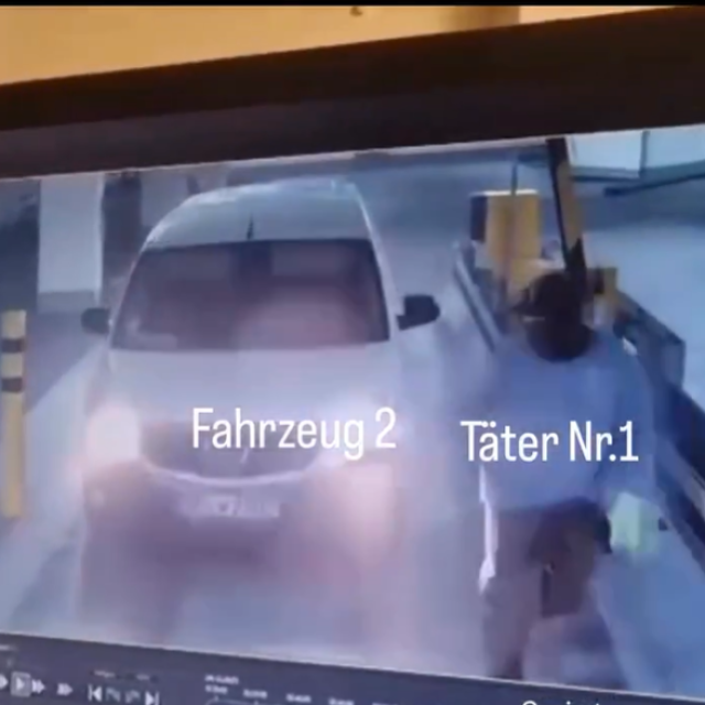 Snimke između ostalog prikazuju maskiranog muškarca kako podiže rampu parkirne garaže, dok drugi maskirani muškarac stoji ispred automata za parkirne karte