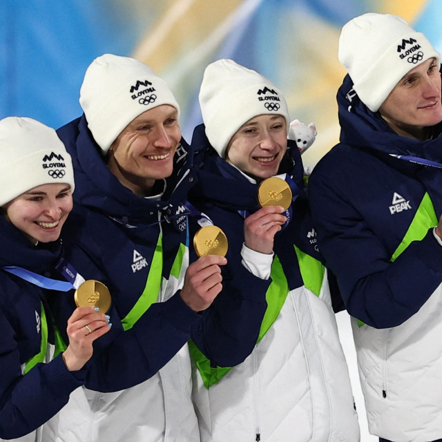 (From L) Slovenia‘s Nika Vodan, Slovenia‘s Anze Lanisek, Slovenia‘s Nika Prevc and Slovenia‘s Domen Prevc celebrate on the podium for the ski jumping mixed team final of the Milano Cortina 2026 Winter Olympic Games at Predazzo Ski Jumping Stadium in Predazzo (Val di Fiemme), on February 10, 2026. (Photo by Anne-Christine POUJOULAT/AFP)
