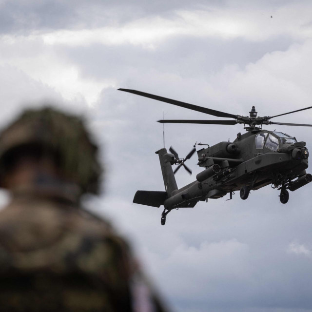 Poljski vojnik gleda američki helikopter Apache AH-64D tijekom zajedničke vojne vježbe