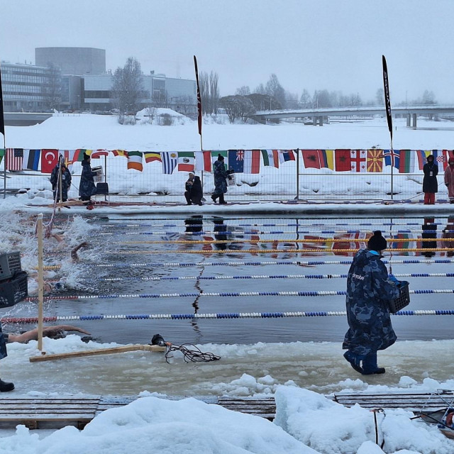 Košare s ogrtačima plivača volonteri nose na finiš