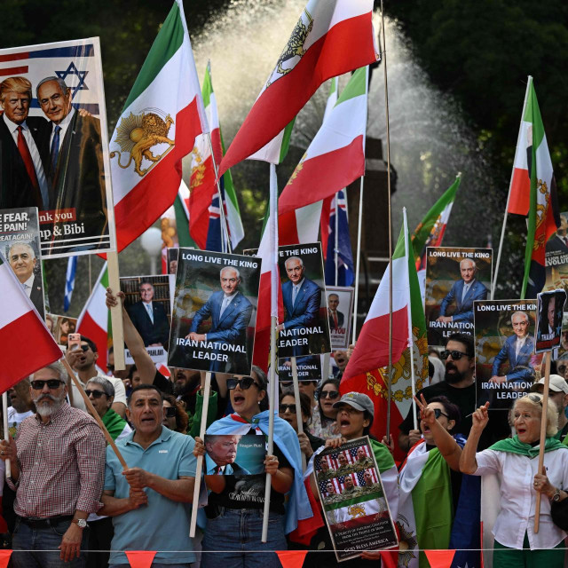 Members of the Iranian community hold placards, wave flags and chant slogans during a rally following US and Israeli attacks on Iran, in Sydney on March 14, 2026. (Photo by Saeed KHAN/AFP)
