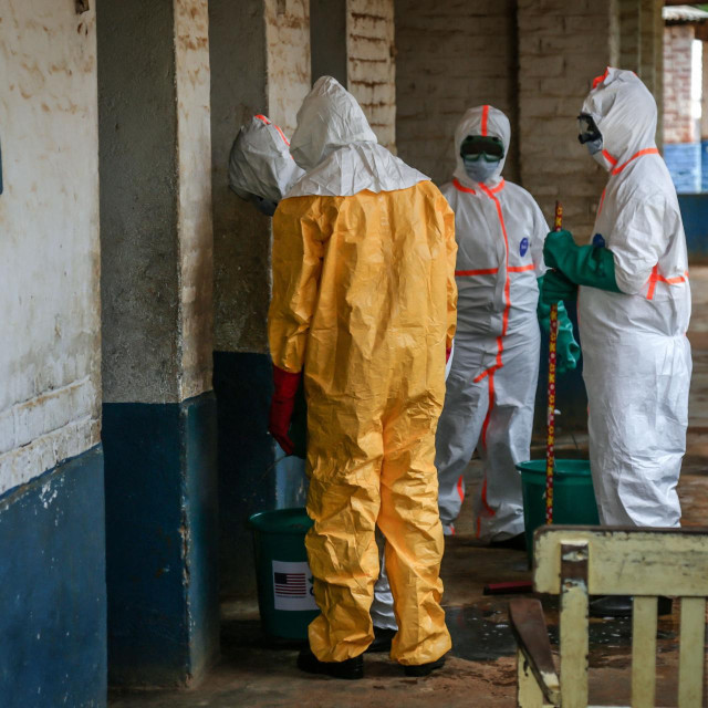 Health workers wearing protective equipment disinfect the isolation area for Ebola patients at the General Referral Hospital of Mongbwalu in Mongbwalu, on May 23, 2026. Ebola continues to spread in Democratic Republic of Congo, where the first cases of transmission were reported in the eastern province of South Kivu, while the health response is struggling to get organized and has given rise to scenes of chaos in Ituri province, the epicenter of the epidemic. The World Health Organization (WHO) issued an international health alert to address a 17th Ebola outbreak in the east of the Democratic Republic of Congo, a vast Central African country of more than 100 million inhabitants plagued by conflict. (Photo by Seros MUYISA/AFP)