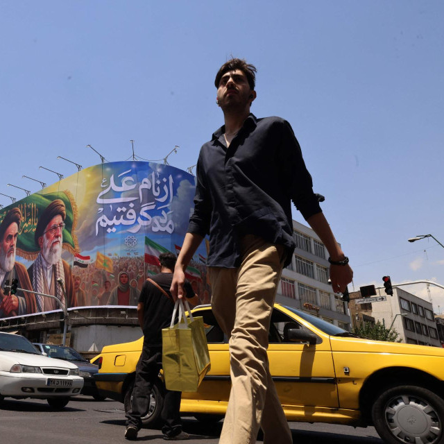 Iranski prolaznici u Teheranu hodaju pokraj reklamnog panoa s portretima pokojnog vrhovnog vođe ajatolaha Ruhole Homeinija i ubijenog vrhovnog vođe ajatolaha Alija Hameneija