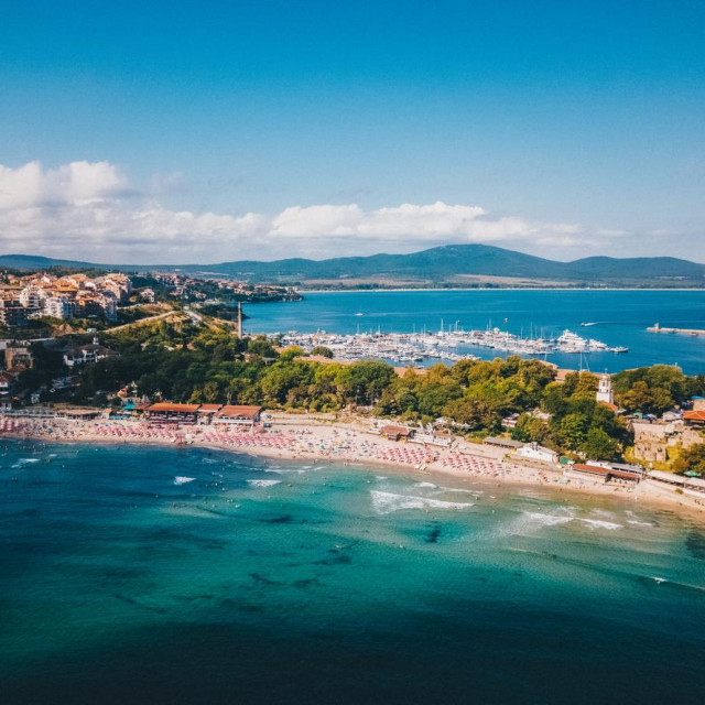 A picturesque aerial shot of Sozopol, Bulgaria, showcasing the charming old town with its historic architecture, sandy beach, and crystal-clear waters of the Black Sea.