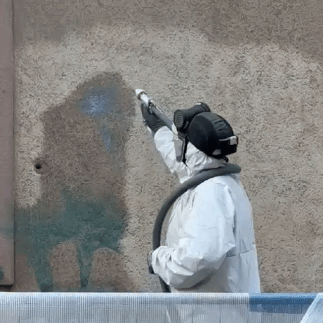Radnik uklanja grafit s fasade