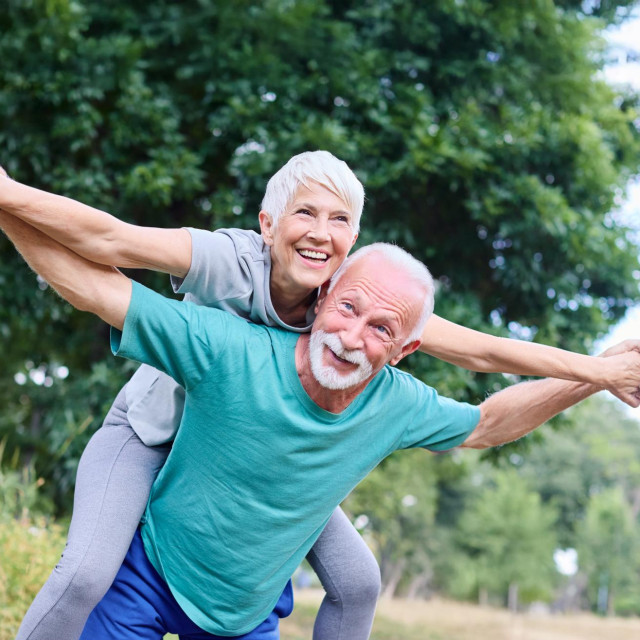 Smiling active senior couple having fun together in the park, active healthy elderly people bonding, older couple happy relationship