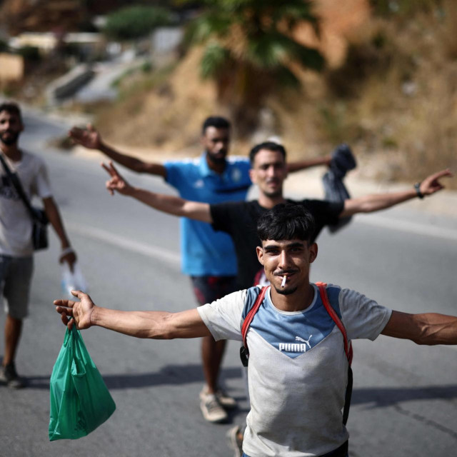Migranti poziraju dok ih španjolske vlasti prate natrag prema granici