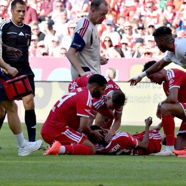 Jamal Musiala leži na travnjaku nakon što se srušio tijekom prijateljske utakmice Bayerna i RB Leipziga, a Ismael Saibari pridržava mu glavu