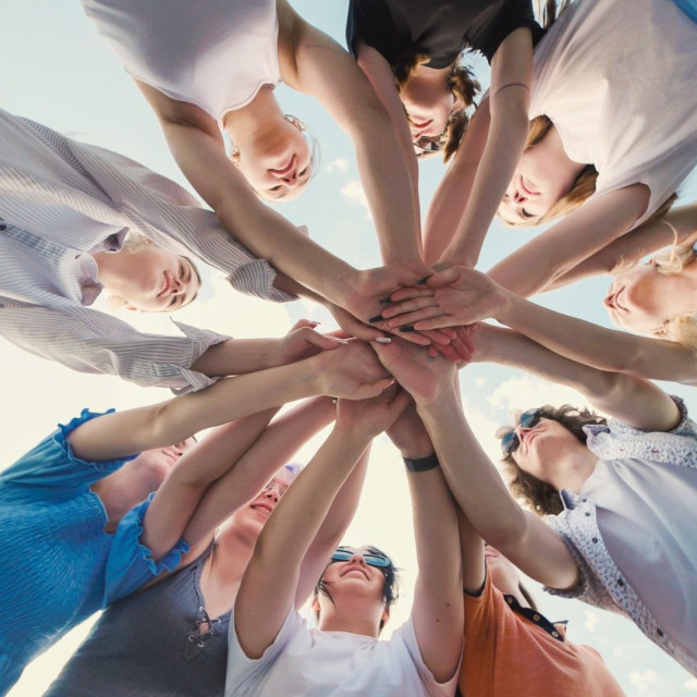 School friends uniting in a circle, holding hands to symbolize their strong bond and teamwork