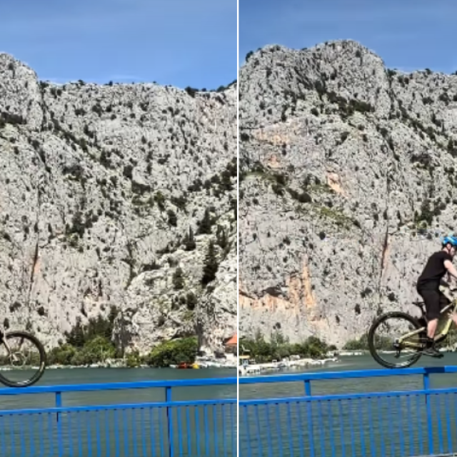 Muškarac vozi bicikl po ogradi mosta