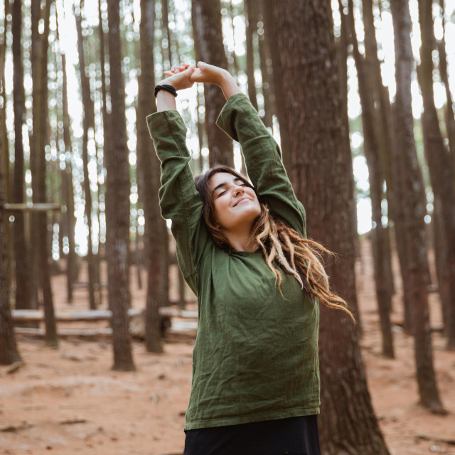 beautiful young woman hiker enjoying and relaxing in a woods up their arm