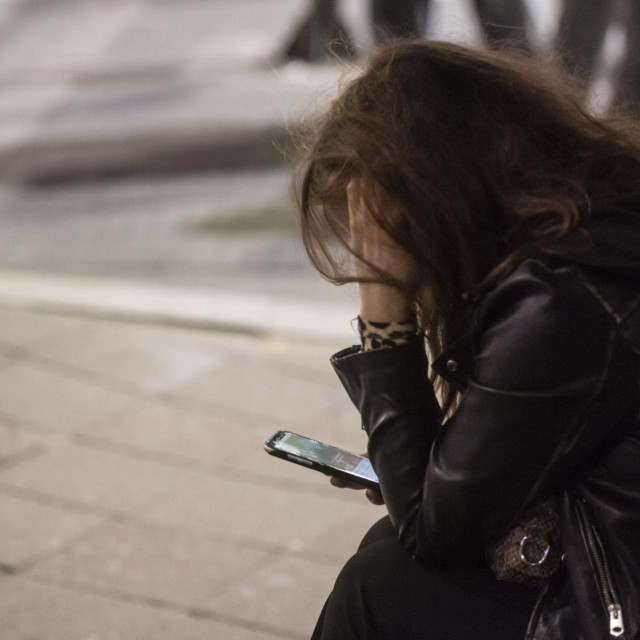 Djevojka s mobitelom u Beogradu prati vijesti